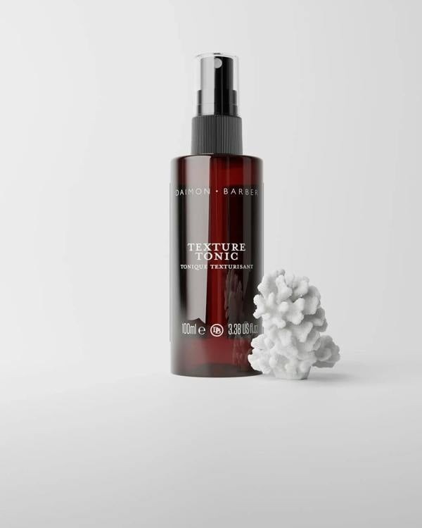 Texture Tonic bottle on grey background with piece of coral