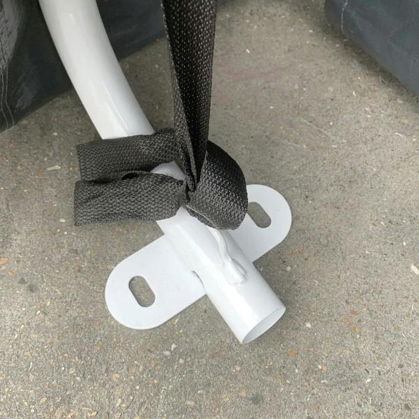 White shed frame base with dark tie strap and ground anchor bracket