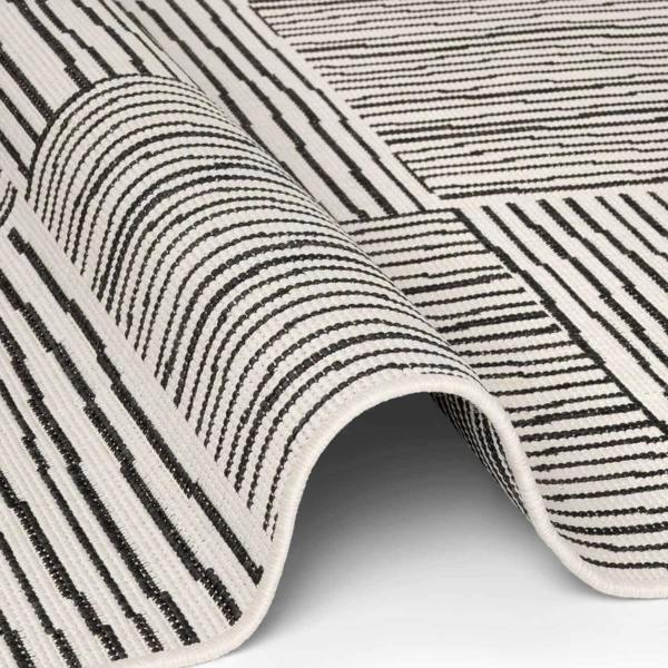 Close-up of a black and white striped rug on a light gray background