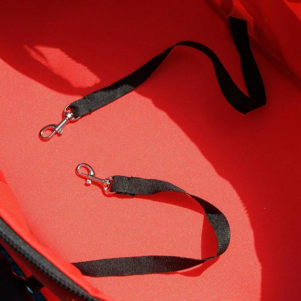 Red pet stroller seat with attached safety leash clips on the fabric panel