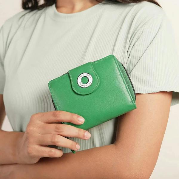 Green wallet held by a person wearing a light green shirt