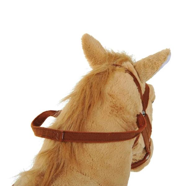 Beige plush horse head with brown bridle and reins, close-up detail