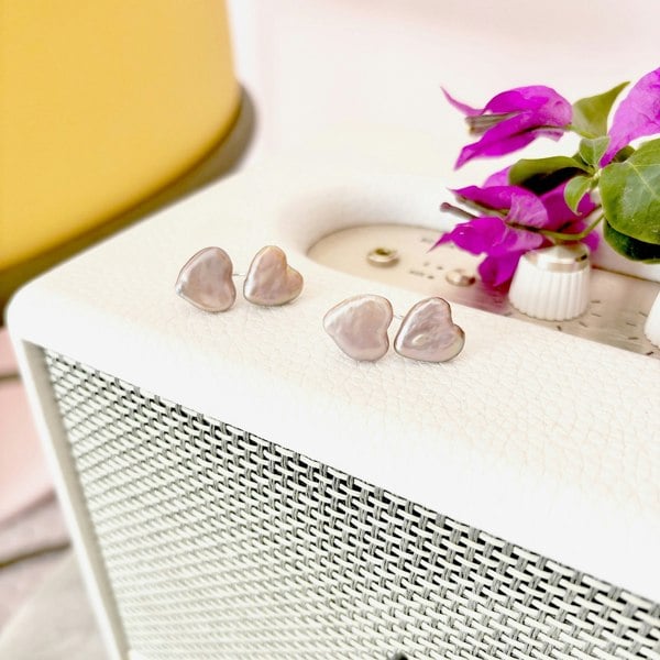 Heart pearl ear jacket earrings displayed on a vintage radio.