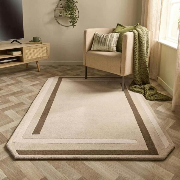 Living room with a beige rug, armchair, and television stand.