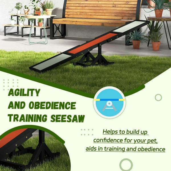 Black wooden agility seesaw with orange center and light anti-slip boards on lawn