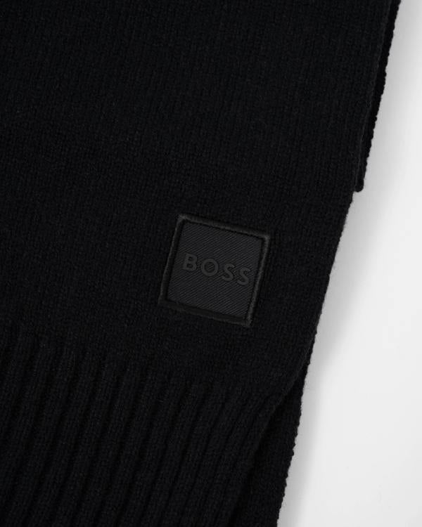 Close up of the logo of BOSS Orange Akaio R Mens plain-knit scarf with woven logo badge - Black 001