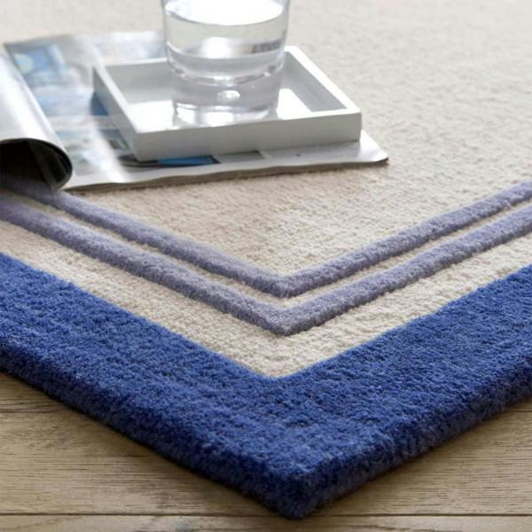 Blue and beige striped rug with a glass of water on top