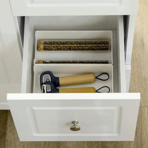 White kitchen island drawer open with organizer shelf and kitchen utensils