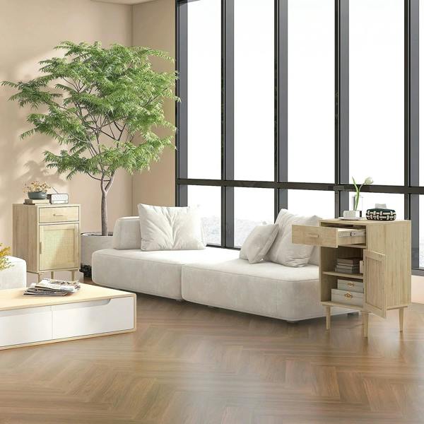 Natural wood bedside cabinet with drawer and rattan-front door, staged in a living room.