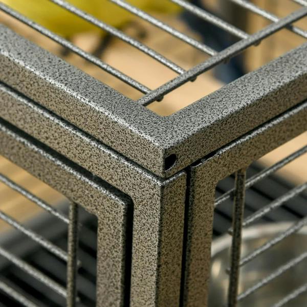 Close-up of black speckled cage frame corner and wire mesh grid bars.