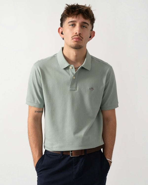 Model wearing a GANT Mens Regular Fit Short Sleeve Shield Logo Pique Polo in Ceramic Grey