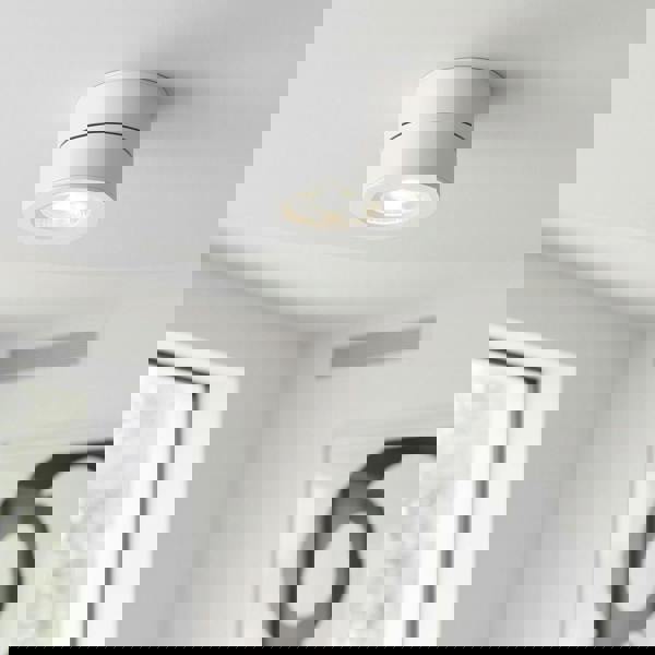 white adjustable ceiling light mounted on a white ceiling in a living room