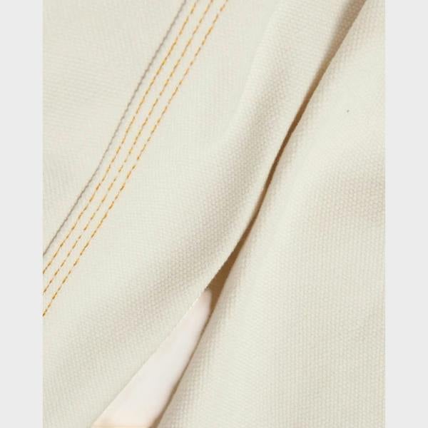 Close-up of Supplied Fashion French terry jacket fabric in off-white with contrasting yellow double-stitch detail.