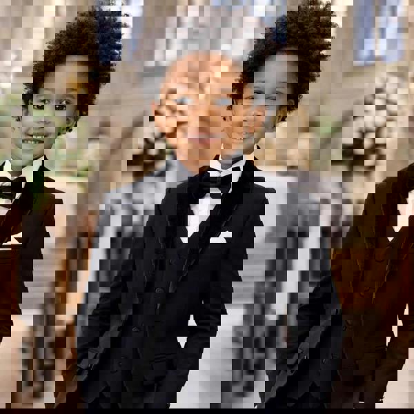 Child in a formal black suit standing in a church setting