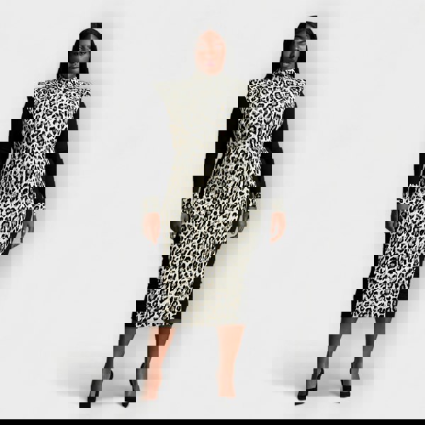 Woman wearing a black white leopard print dress with black sleeves on a white background