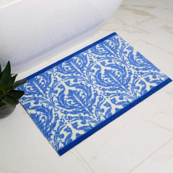 Blue and white patterned bath mat on a tiled bathroom floor.
