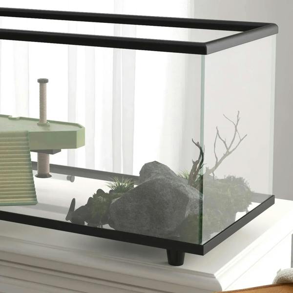Glass turtle tank corner view with black frame, basking platform, and rock decor