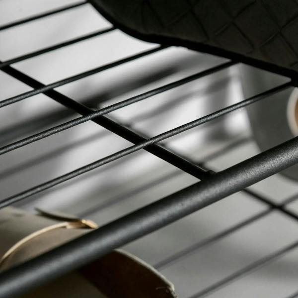 Close-up of black wire grid shelves on the shoe bench