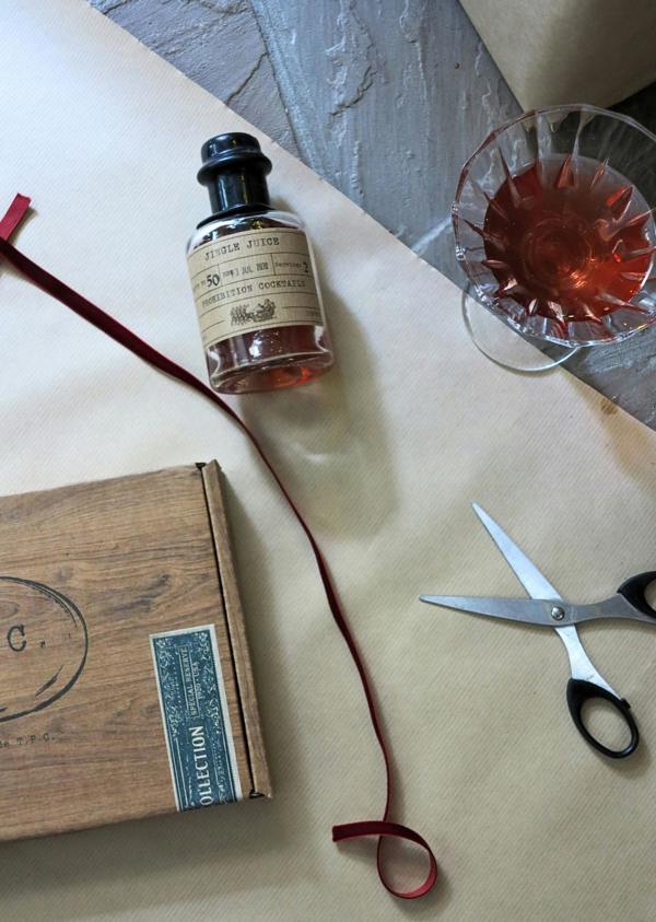 A styled flat-lay featuring a small bottle of Jingle Juice by Prohibition Cocktails