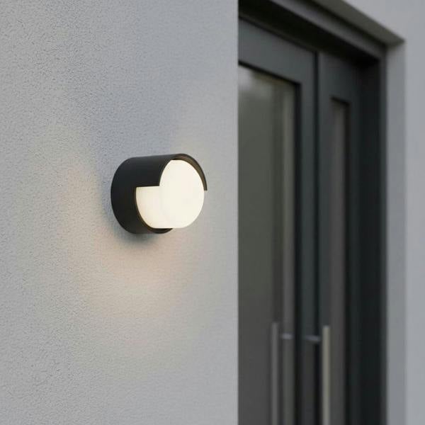 black outside wall lamp mounted on a textured outside wall next to a front door