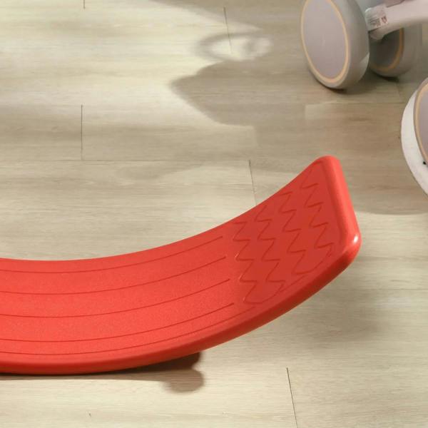 Red curved wobble balance board with textured grip panel on the top