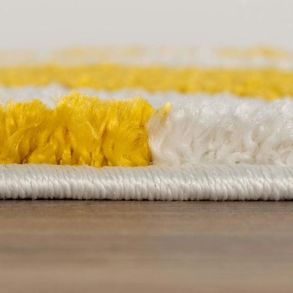 Close-up of a yellow and white scrub brush on a wooden surface.