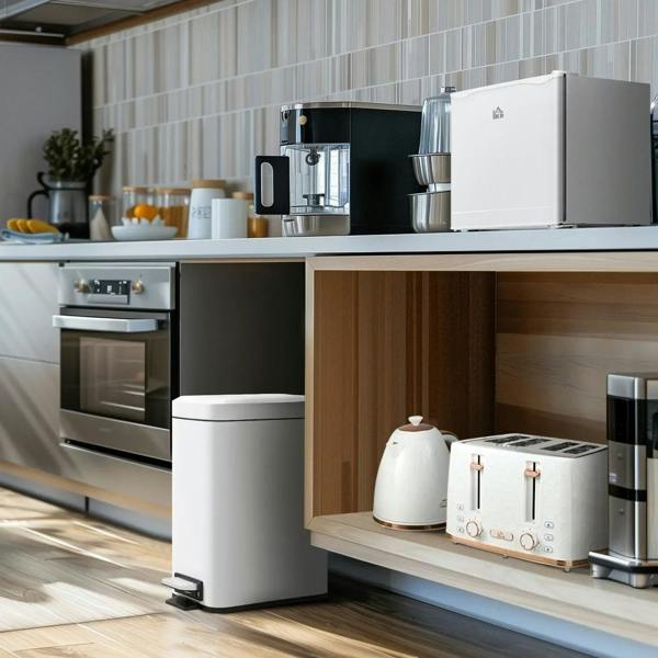 Cream mini fridge on countertop near other appliances, compact ice box unit