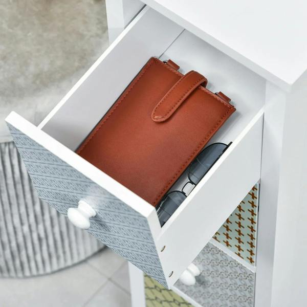White storage cabinet with open top drawer holding a brown wallet and small items.