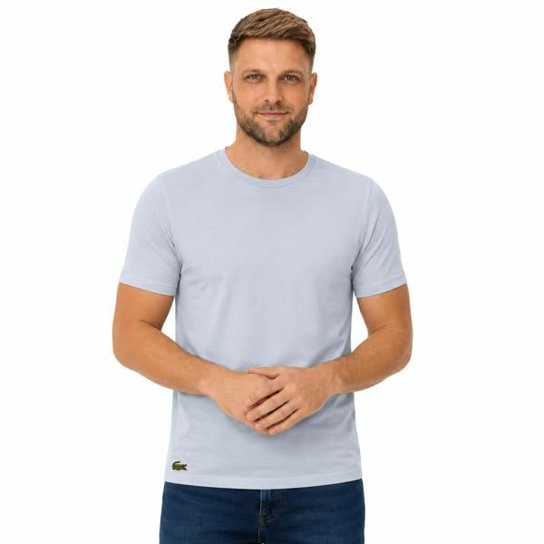 Man in a light blue Lacoste cotton lounge t-shirt with a small crocodile logo.