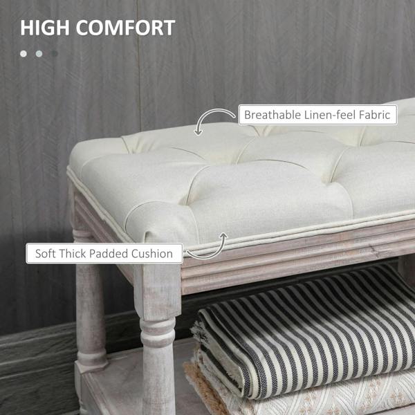 Cream padded footstool bench with button-tufted cushion and lower storage shelf