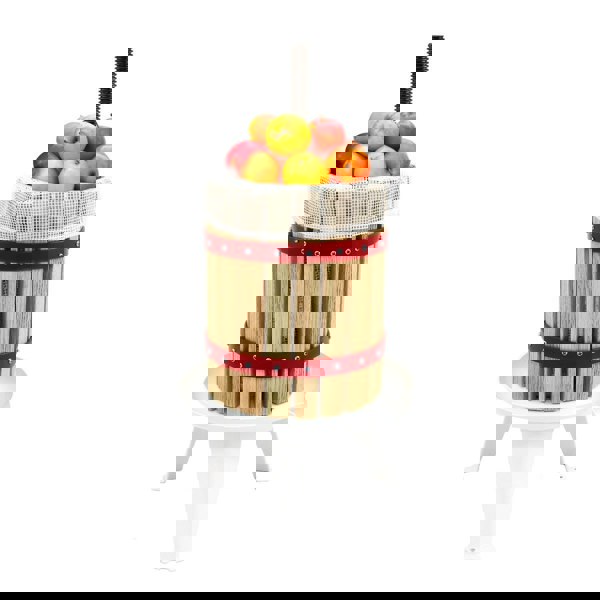 KuKoo 12 Litre Fruit Press with wooden slats, red metal bands, and a mesh top filled with fresh apples on a white base