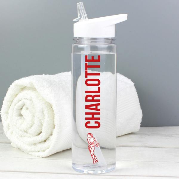 A transparent 750ml sports water bottle custom-printed with the name 'Charlotte' in vibrant red vertical font above a female athlete graphic holding a ball, positioned in front of a rolled white gym towel.