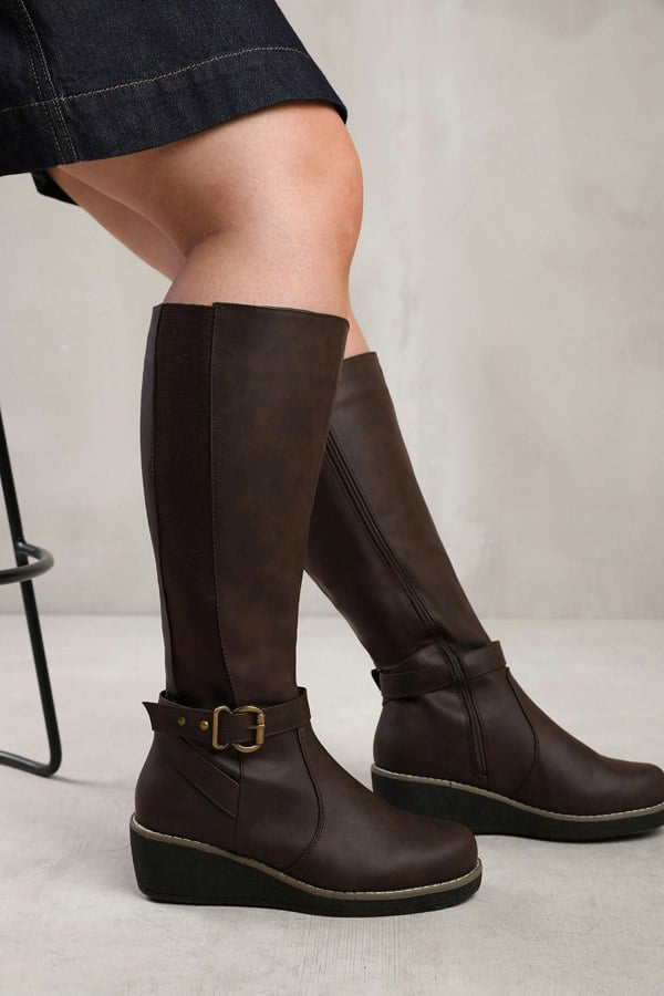 Where's That From Ayleen Wide Calf Wedge Heel Knee High Boots With Elastic Panel in Wide E Fit in Brown Faux Leather