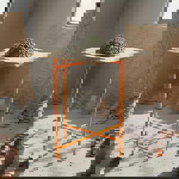 Mortar board stand in bright orange, 750mm high, supporting a mound of wet mortar on a construction site with tools and materials around