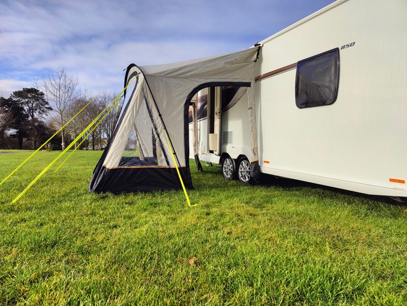 An image of the View Lite 260 Caravan Awning from OLPRO in a field attached to a caravan.