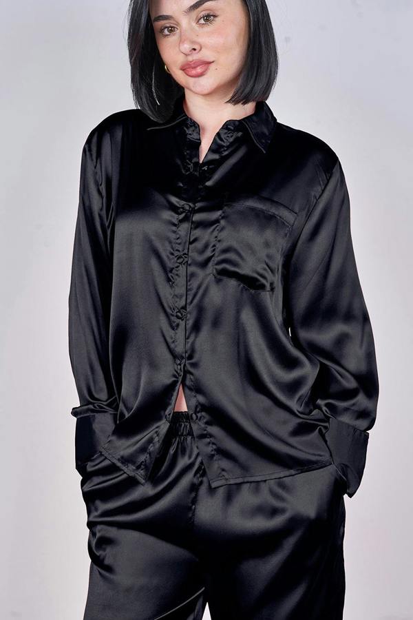 Person wearing a black satin outfit on a plain background