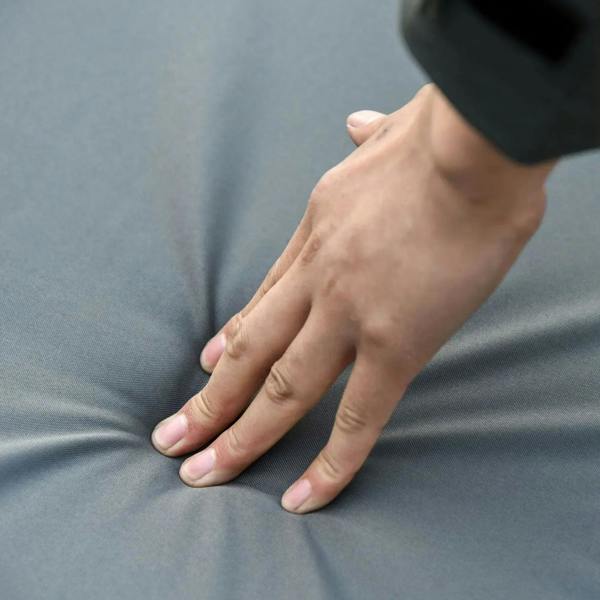 Grey outdoor cushion fabric being pressed by hand