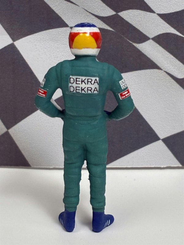 a toy figure of a man wearing a racing suit