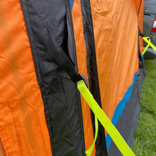 A storm strap attaches to the air beam of a Loopo Breeze® v2 Inflatable Campervan Awning by OLPRO imageset:Orange