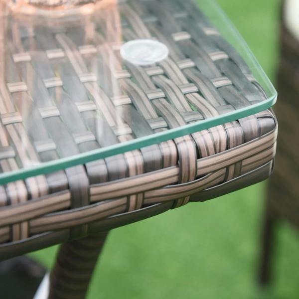 Close-up of brown rattan table frame with tempered glass tabletop edge