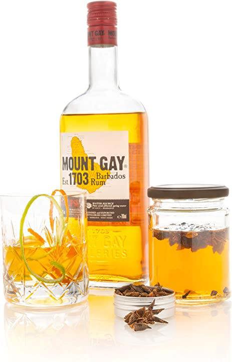 A Glass of Rum Infused with Natural & Noble Star Anise Next To A Bottle Of Rum