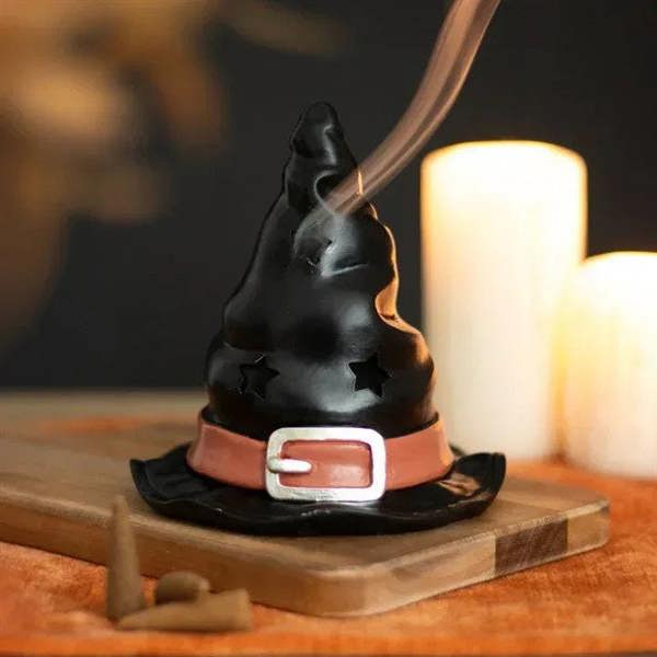 Black witch hat incense burner with red band; burning incense cone emits smoke