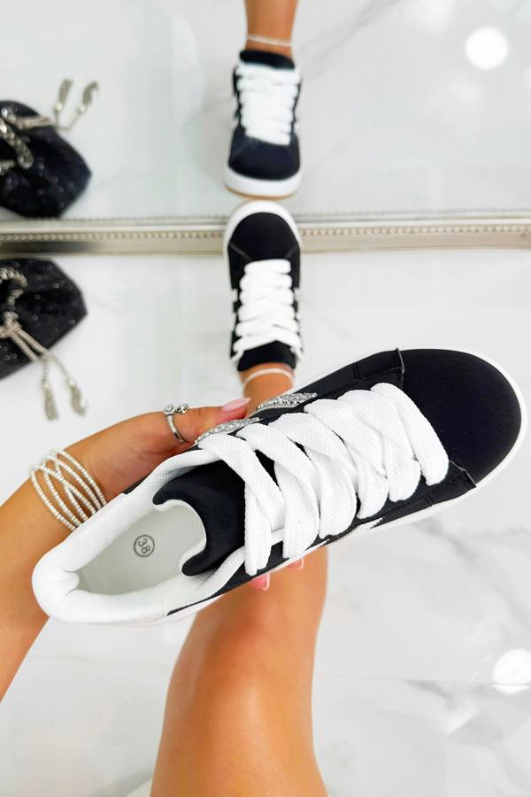 Black and white sneakers being worn with a blurred background