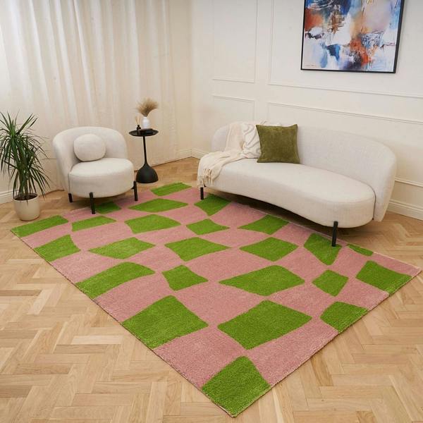 Living room with a pink and green checkered rug, white sofa, and armchair.