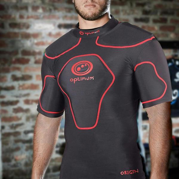 Man wearing black Optimum Origin rugby protective top with red trim and logo, brick wall setting - Optimum