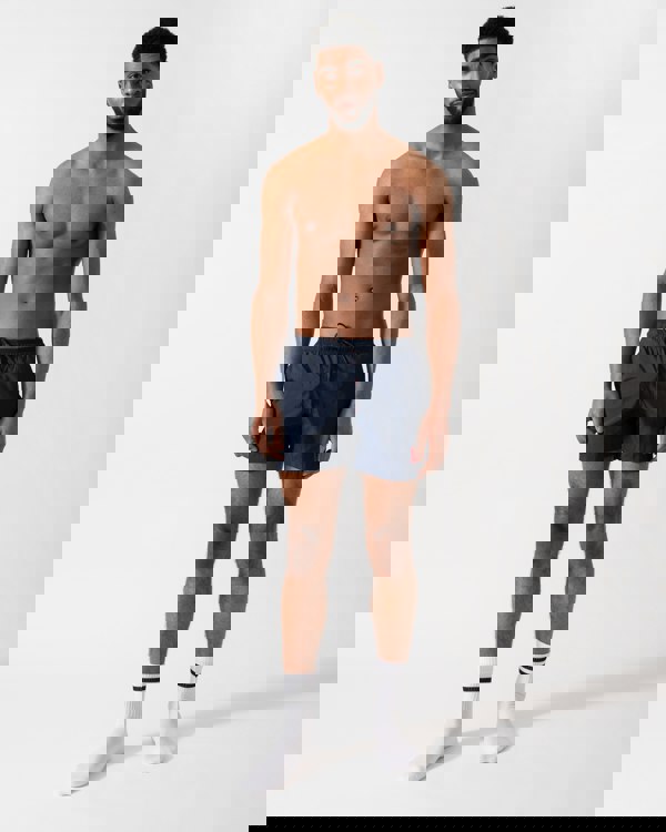 Full length shot of a Model wearing a HUGO Dominica Mens Quick-Drying Swim Shorts In Recycled Material With Logo in Dark Blue