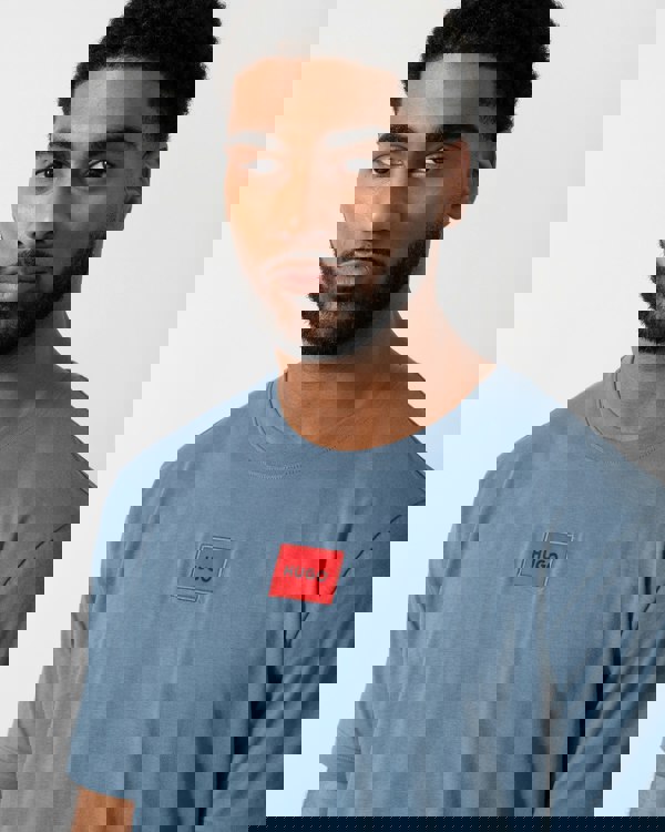 Detail shot of a Model wearing a HUGO Diragolino212 Label Logo Mens T-Shirt in Open Blue