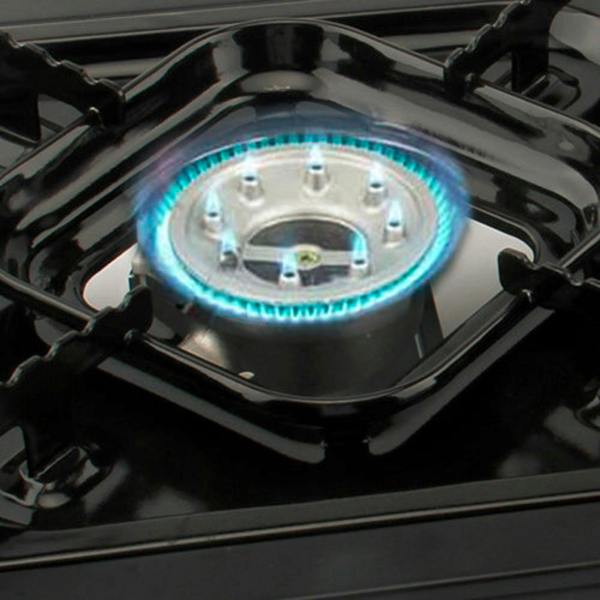 Gas stove burner with blue flames on a black stovetop