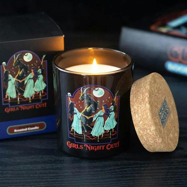 Black scented candle jar with illustrated Girls Night Out graphic, lid open, flame.