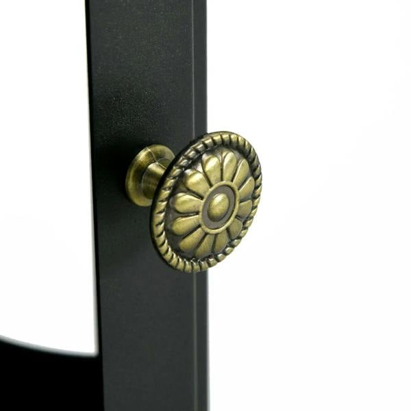 Black fireplace panel with brass-tone round control knob